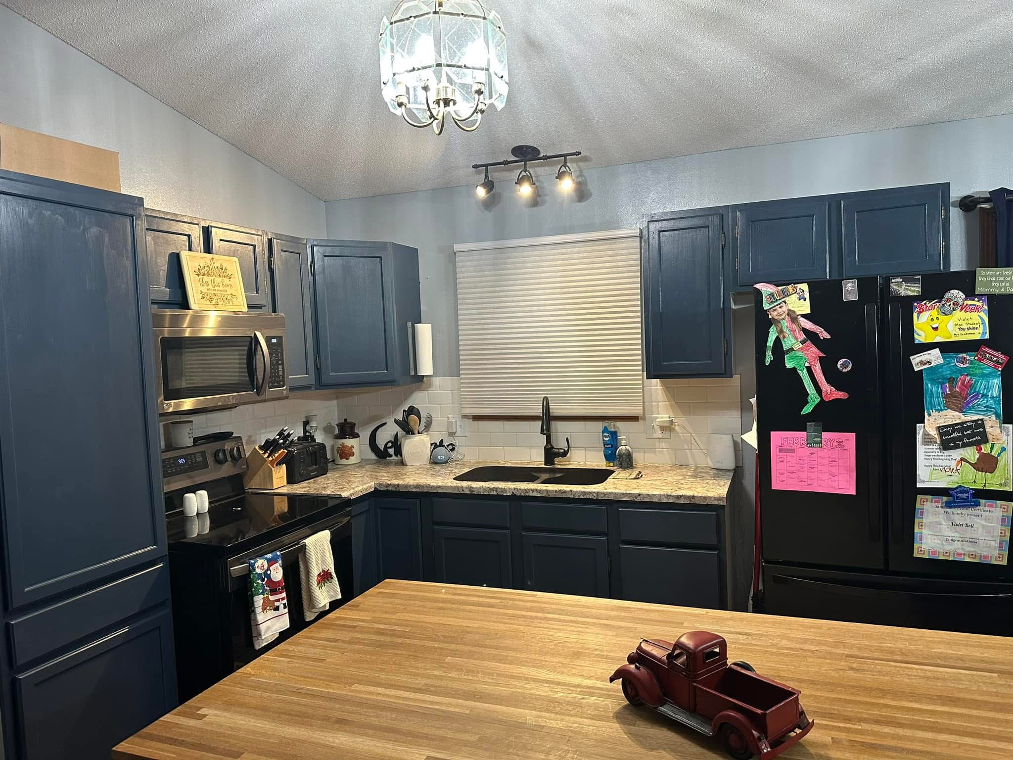 Completed kitchen refresh with navy cabinets and clean finished surfaces