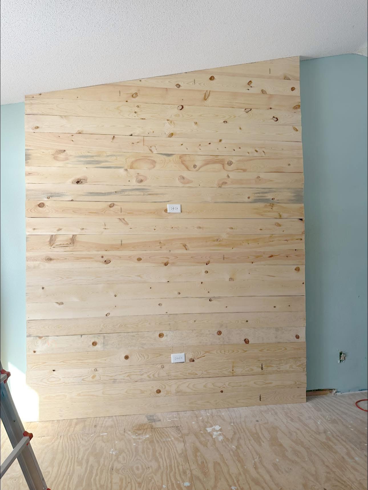 Custom wood-plank television feature wall during construction