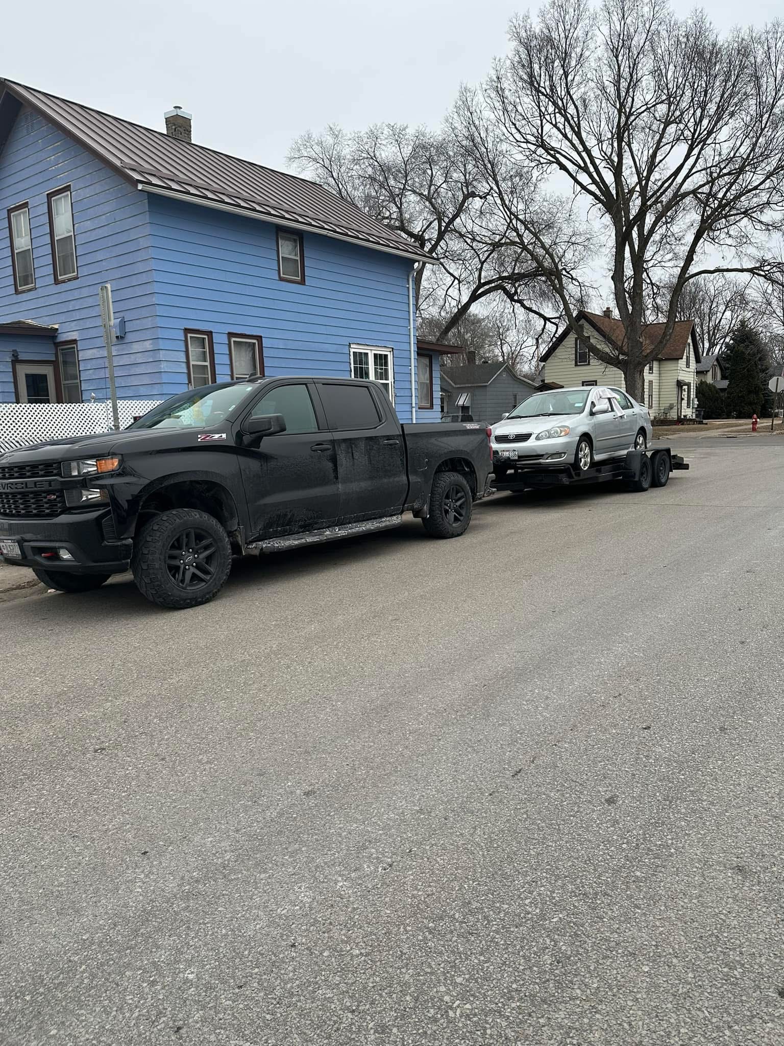 Rustic Memories truck towing a car secured on a flatbed trailer