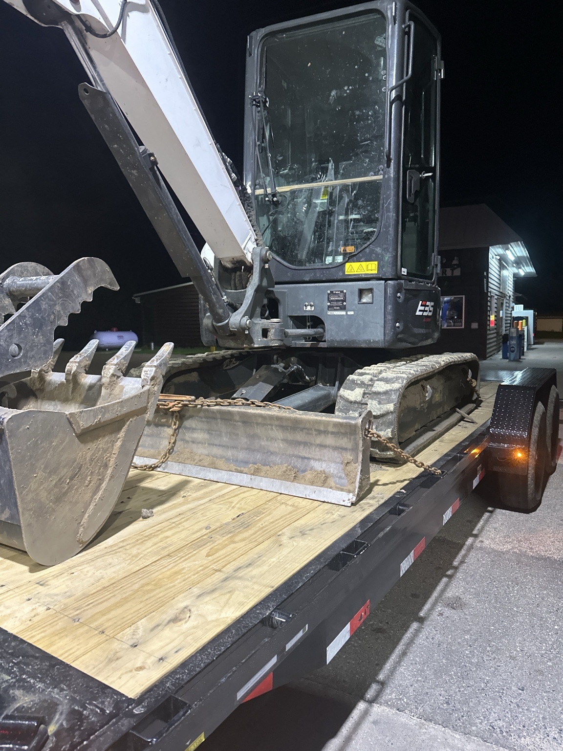 Compact excavator secured on a trailer for transport